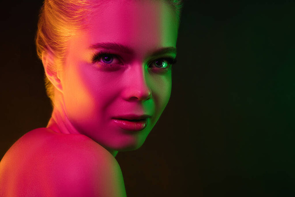 Retrato de modelo de moda feminina em luz de néon no fundo escuro estúdio. - Foto, Imagem