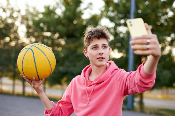 young caucasian basketballer take photo of himself with ball - Fotó, kép