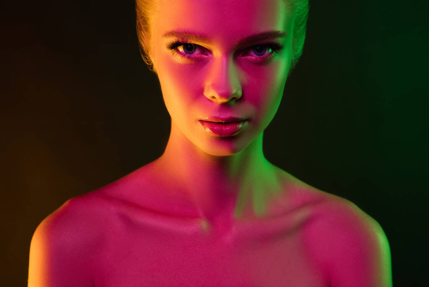 Portrait of female fashion model in neon light on dark studio background. - Fotografie, Obrázek