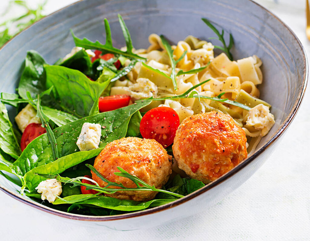 Italian pasta. Pasta  with meatballs,  cheese and fresh salad on light background. Dinner.  Slow food concept - Photo, Image