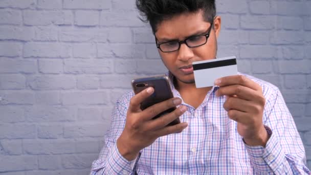 szczęśliwy człowiek ręka trzymając kartę kredytową i przy użyciu smartfona zakupy online  - Materiał filmowy, wideo