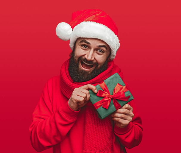 Excited man in Santa hat on red background - Foto, imagen