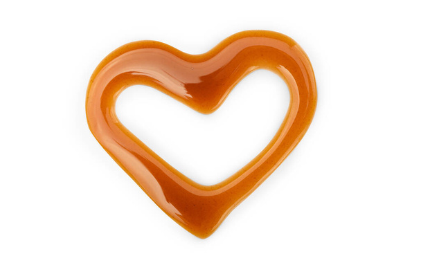 Sweet caramel topping in shape of heart isolated on white background. Top view. - Photo, Image