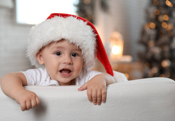 Cute little baby wearing Santa hat at home. Christmas celebration - Foto, Imagen