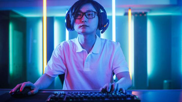 Handsome Young IT Specialist Uses Computer, Browses in Internet, Plays Online Games, Does Hacking. Cool Neon Lights in His Room. - 写真・画像