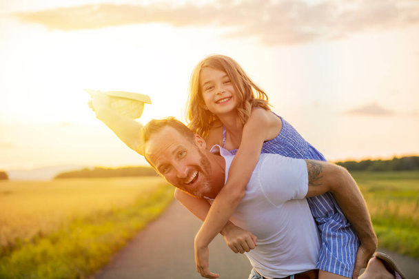 happy family at sunset. father and daughter having fun and playing in nature - Fotoğraf, Görsel