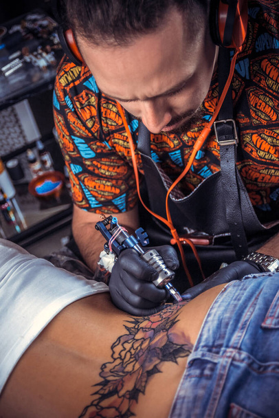 Tetováló művész teszi hűvös tetoválás tetoválás szalonban - Fotó, kép