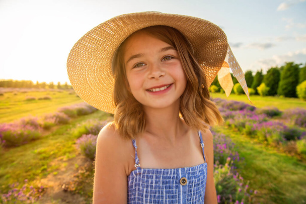 portrait of young blonde girl in the colour dress in the field of lavander - Foto, afbeelding