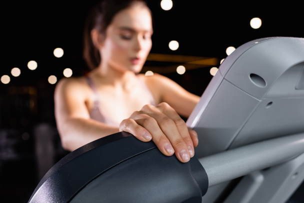 blurred sportswoman training on treadmill in gym - Фото, изображение
