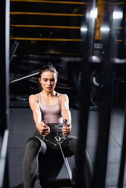 vysoký úhel pohledu sportovkyně trénink na veslování stroj na rozmazané popředí - Fotografie, Obrázek