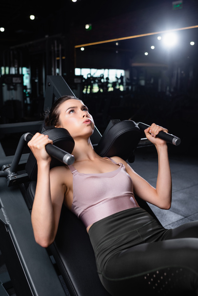 jeune femme sportive s'entraînant sur une machine d'extension des bras en salle de gym - Photo, image
