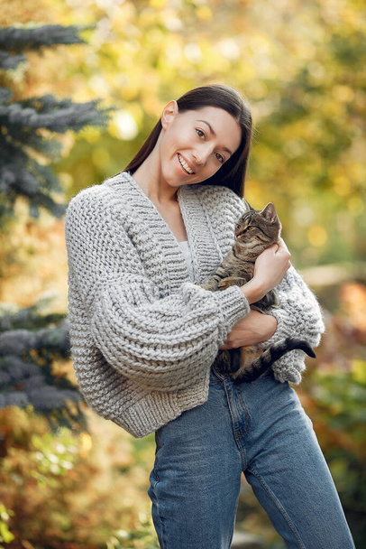 Girl in a kniten sweater standing on trees background - Photo, image