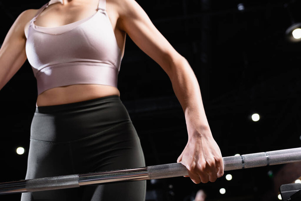 cropped view of athletic sportswoman lifting power rack in sports center - Zdjęcie, obraz