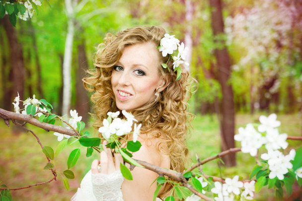 Beautiful bride in a white dress in blooming gardens in the spring - Φωτογραφία, εικόνα