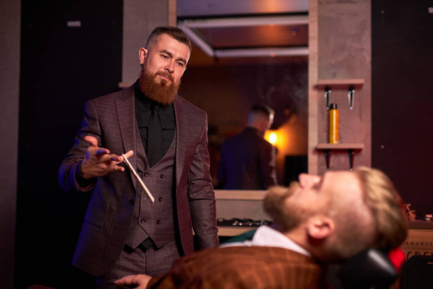 barbero masculino está listo para cortar a su cliente sentado en la silla - Foto, imagen