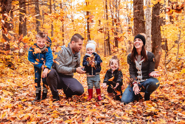 A portrait of a young family in the autumn park - Фото, зображення