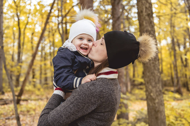 A portrait of a mother with child in the autumn park - Photo, Image