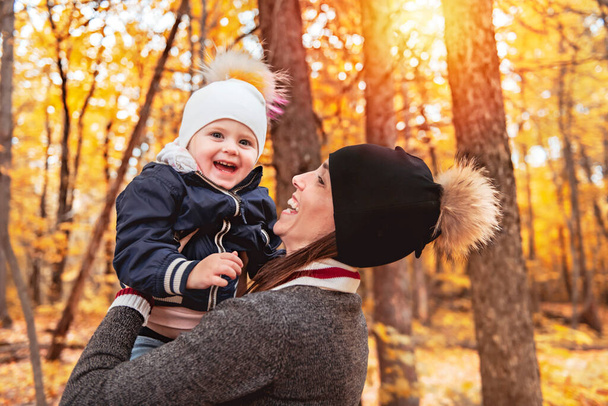 Un retrato de una madre con un niño en el parque de otoño - Foto, Imagen