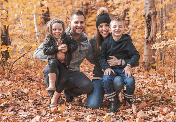 A portrait of a young family in the autumn park - Фото, изображение