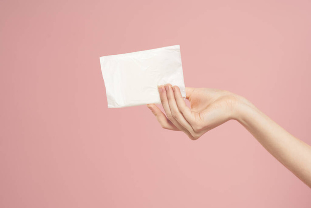Укладання в упаковці в жіночі руки на рожевому тлі обрізаний вид гігієни чистого вигляду
 - Фото, зображення