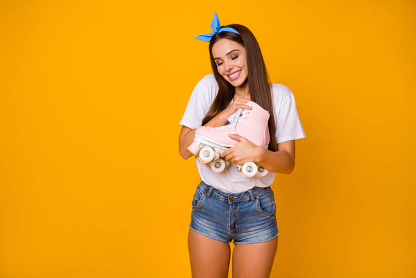 Portrait of pretty charming sweet girl hug embrace her pink trend roller skates enjoy wear white t-shirt denim jeans shorts isolated over bright color background - Foto, afbeelding