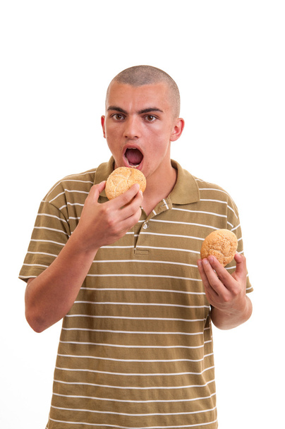 Young man eating buns with sesame - Zdjęcie, obraz