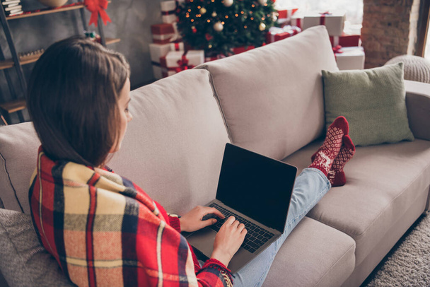 Photo of lovely young girl sit couch hold netbook wear plaid red socks jeans in decorated x-mas living room indoors - Foto, Imagem