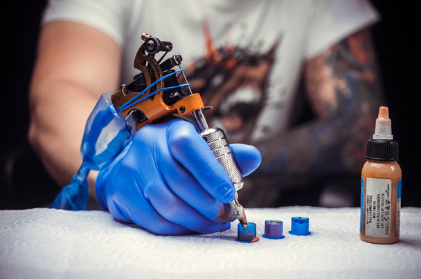 Рука художника татуювання з татуюванням машини
. - Фото, зображення
