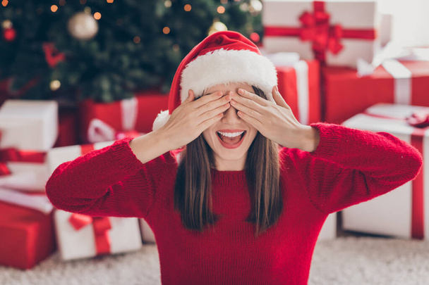 Photo of funny youn woman boxes open mouth arms cover eyes wear santa cap red pullover in decorated x-mas living room indoors - Fotoğraf, Görsel
