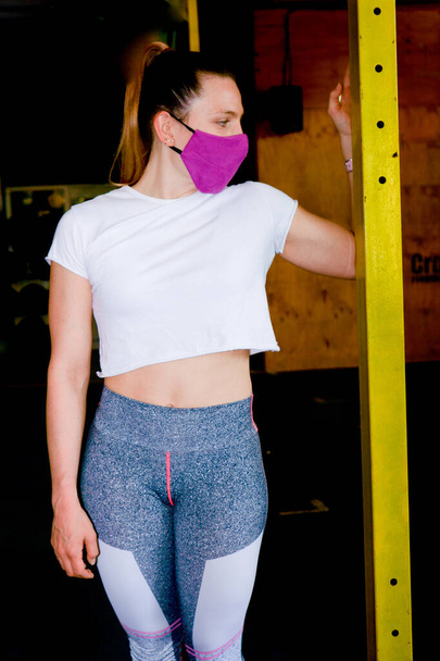 Νεαρή γυναίκα κάνει διάφορες ασκήσεις στο γυμναστήριο - Φωτογραφία, εικόνα