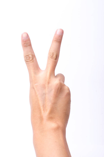 Hand with two fingers up in the peace or victory symbol. Also the sign for the letter V in sign language. Isolated on white. - Zdjęcie, obraz