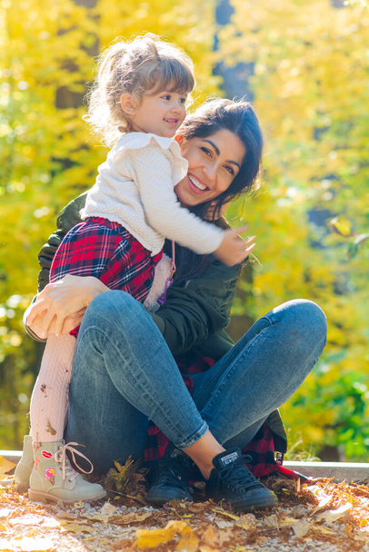 Happy Mother Hugging  her Child in the Autumn Park .Mother and Daughter .Happy Family, Mother with Little Child in the Nature - Foto, Imagen