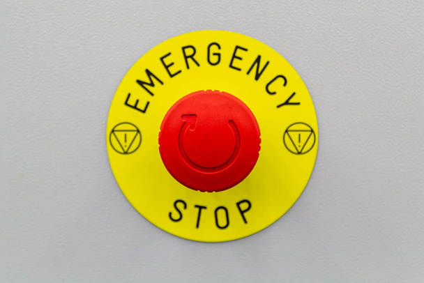 Prima o botão de paragem de emergência no fundo cinzento. - Foto, Imagem