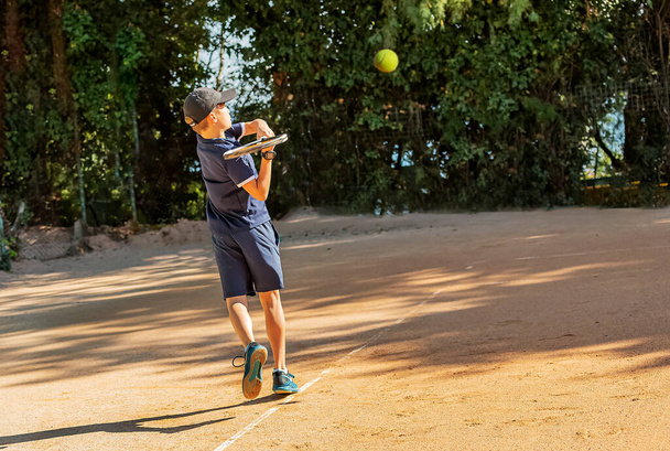El joven tenista participa en sus primeras competiciones. Él maneja con éxito la bola más difícil sirve. - Foto, imagen