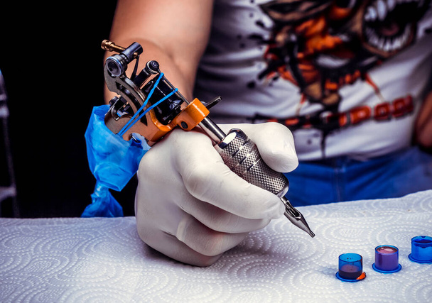 Mano de un tatuador, sosteniendo la máquina de tatuaje. - Foto, imagen