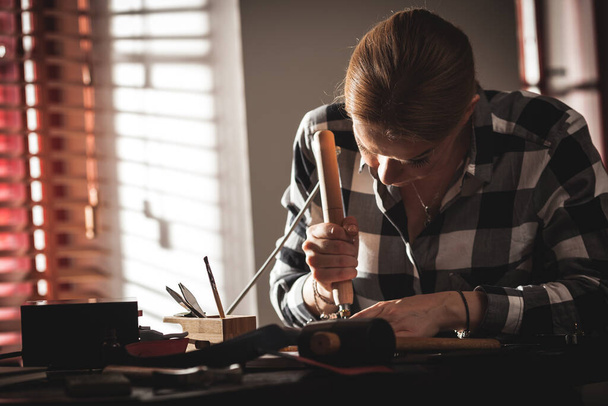 Leather handbag craftsman at work in a vintage workshop. Small business concept - Foto, Imagen