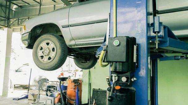 Podnoszenie samochodów w przemyśle samochodowym serwis maszyn do mocowania szczegółów napraw w warsztacie - Zdjęcie, obraz