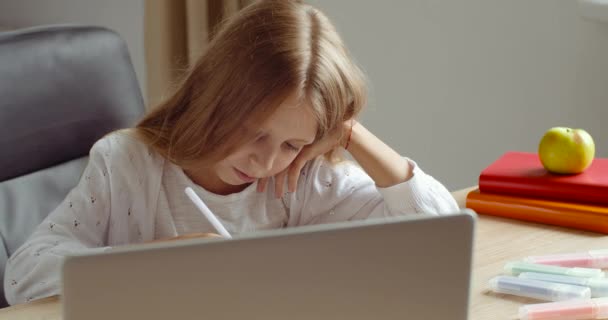Távolságtanulás, szőke iskolás lány, aki otthonról tanul online, laptoppal jegyzetel a másolóban. Tini lány iskolás diák néz internetes videó tanfolyam beszél tutor webkamerával - Felvétel, videó
