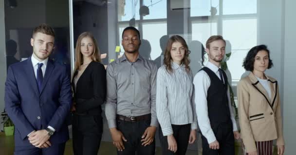 Serious multiethnic business group posing with arms crossed showing team support, strength. Office colleagues co-workers stand in line in conference room. Concept of teamwork, unity and partnership - Footage, Video