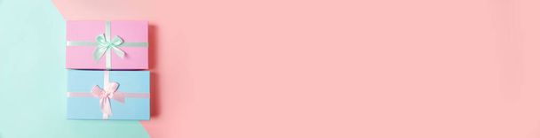 Weihnachten Silvester Geburtstag valentine Feier präsentieren Konzept. Einfach minimalistisches Design blau rosa Geschenkbox isoliert auf rosa blau pastellfarbenen geometrischen Hintergrund. Flache Lageansicht Kopierraum-Banner - Foto, Bild