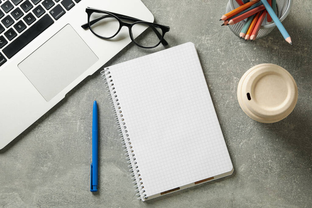 Local de trabalho com notebook em branco no fundo cinza, vista superior - Foto, Imagem