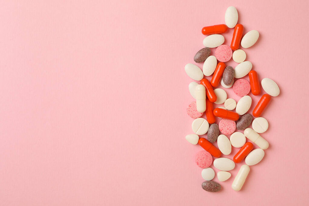 Különböző tabletták rózsaszín háttér, helyet a szöveges - Fotó, kép