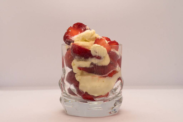 Γλυκό Στράουμπερι με κρέμα σερβιρισμένη σε γυάλινο ποτήρι. - Φωτογραφία, εικόνα