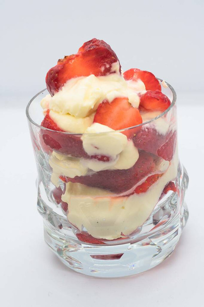 STRAWBERRY DESSERT WITH CREAM SERVED IN A GLASS GLASS - Photo, Image