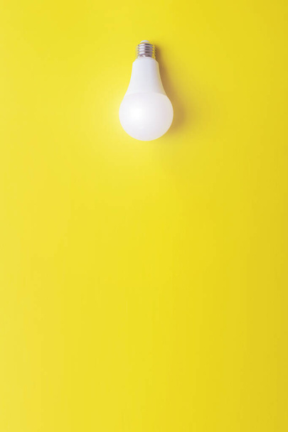 Glowing bulb on yellow background, uniqueness concept. Idea, innovation, creativity concept, design template, copy space - Photo, Image