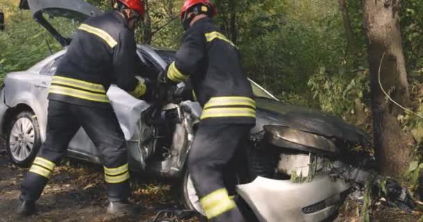 Feuerwehr demontiert kaputtes Fahrzeug nach Crash - Filmmaterial, Video