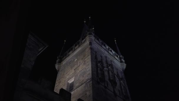 illuminated old stone tower on Charles Bridge from 14 century at night in the center of Prague - Footage, Video