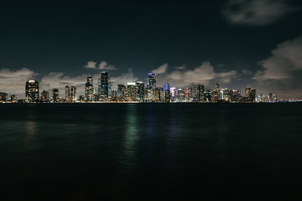 Pohled na Miami Skyline přes Biscayne Bay s bouřkovými mraky nad hlavou v noci - Fotografie, Obrázek