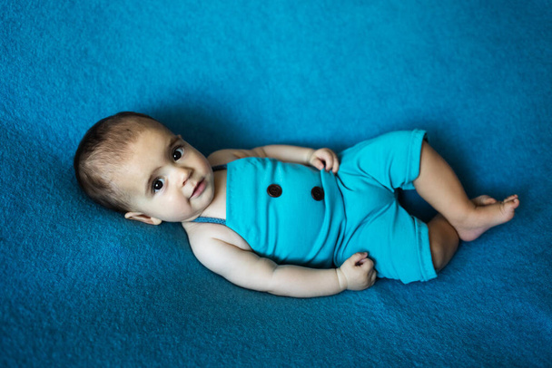 Söpö vastasyntynyt vauva. Onnellinen vauva sinisellä taustalla. Lähikuva muotokuva vastasyntyneen vauvan. Vauvan tavaroiden pakkausmalli. Lastenhuone. Lääketieteellinen ja terve käsite. Joulu. Uusi vuosi - Valokuva, kuva