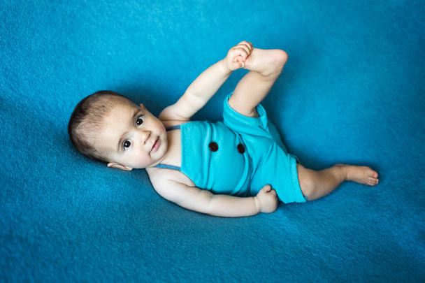 Söpö vastasyntynyt vauva. Onnellinen vauva sinisellä taustalla. Lähikuva muotokuva vastasyntyneen vauvan. Vauvan tavaroiden pakkausmalli. Lastenhuone. Lääketieteellinen ja terve käsite. Joulu. Uusi vuosi - Valokuva, kuva
